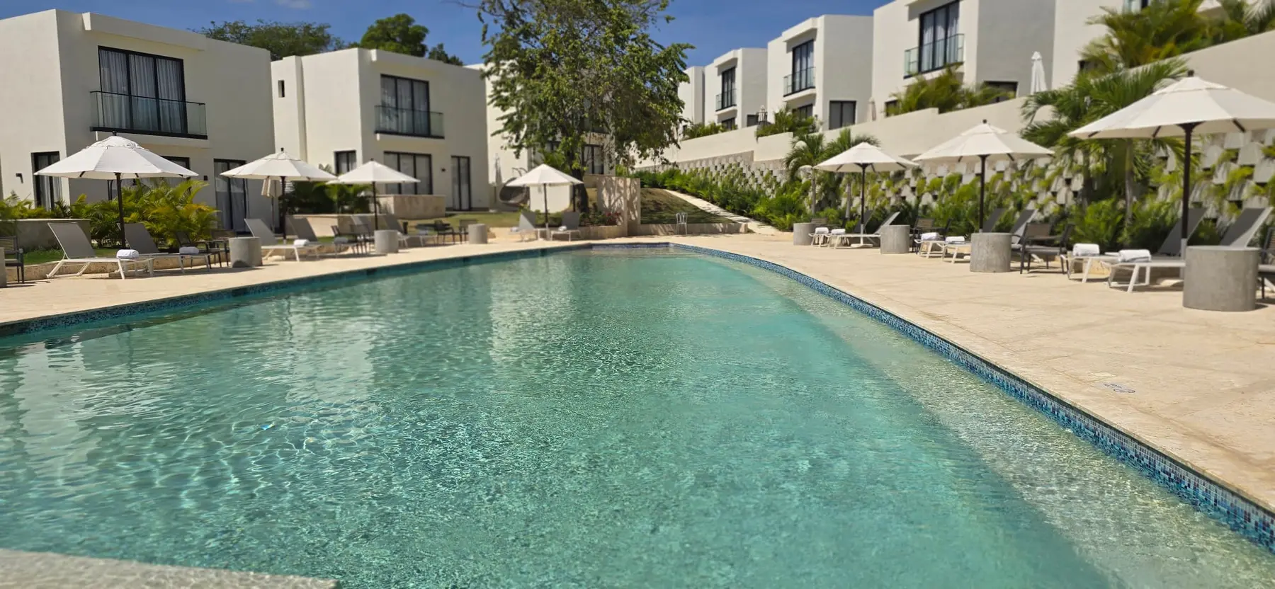 Large swimming pool surrounded by resort villas in Puerto Plata